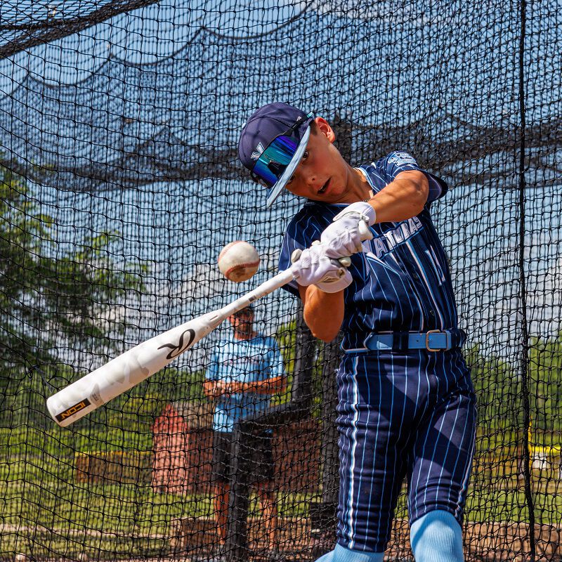 Picture of a player hitting a ball in a batting cage with a 2025 Icon USSSA bat loading=